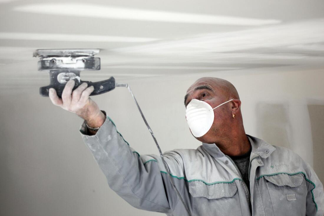 man scraping the ceiling